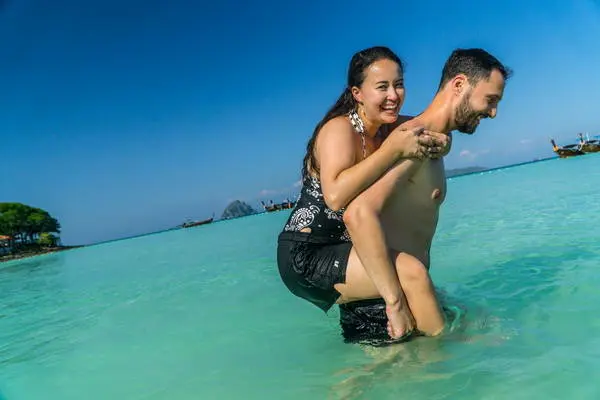 funny moment of a newlywed couple in the sea water