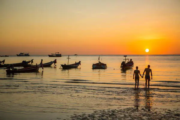 romance time for a loving couple walking on Sairee beach, the most beautiful sunset point in Thailand